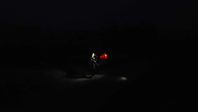 Beleuchtetes Fahrrad auf einem dunklen Radweg