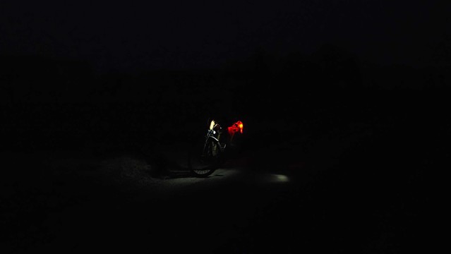 Beleuchtetes Fahrrad auf einem dunklen Radweg