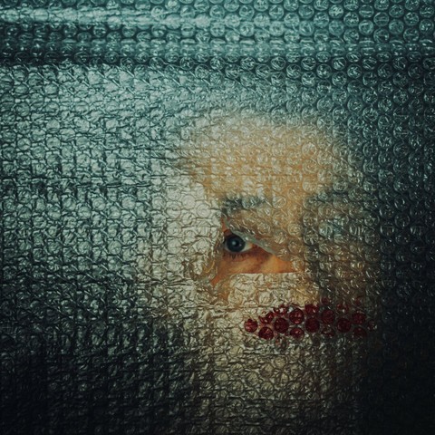 Studio Fotografie Kunst Mann hinter Luftpolsterfolie nur Auge sichtbar