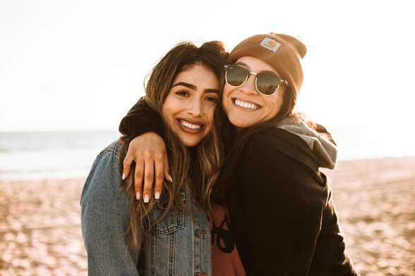 Two women embracing, photographed by Omar López/Unsplash.