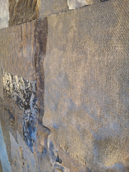 Des toiles de lin tissées collées sur un mur