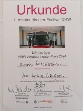 Beschrftung lautet wie folgt:
Urkunde
1. Amateurtheater-Festival NRW
1. Preisträger
NRW-Amteurtheater-Preis 2024
Theater MINESTRONE
mit der Inzenierung
Die kahle Sängerin
Wir bedanken uns für dies herausragende Darbietung.
3 Unterschriften