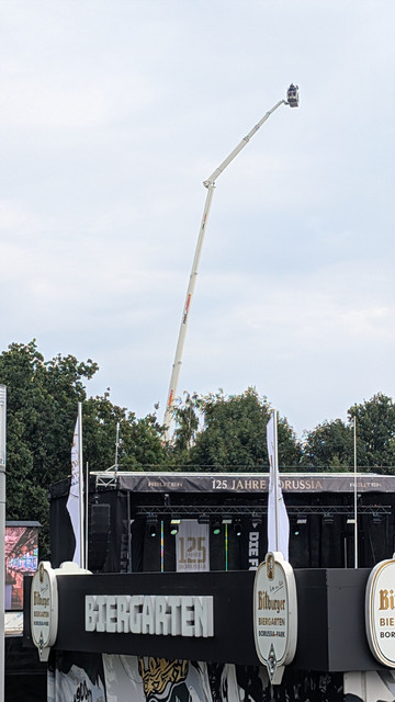 Der Ausleger eines wirklich ungewöhnlich hohen Krans mit Menschen in einem "Korb" an der Spitze schwebt neben dem Borussia-Park. 