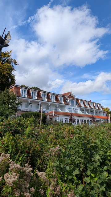 Außenansicht des Hotels Wassersleben, an und in dem viele Szenen der ZDF Serie Dr. Nice spielen. Es ist weiß mit einem roten Dach. 