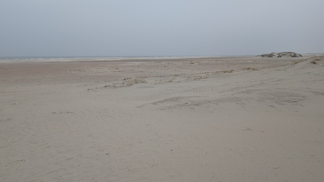 Der Strand "Oase" auf Norderney. Es ist farblich ein Arrangement aus Grau, das so eben noch die Unterschiede zwischen Strand, Meer und Himmel erkennen lässt. 