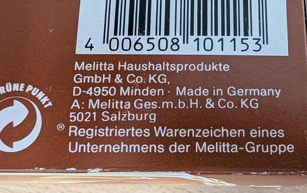 Foto der Adressenformation des Herstellers Melitta auf der braunen Verpackung.
Die Besonderheit ist die vierstellige deutsche Postleitzahl. 